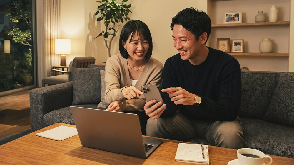 スマートフォンやPCでフライトや旅程を検索・予約している男女